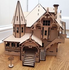 a paper model of a house on a wooden table with stairs and steps leading up to the second floor