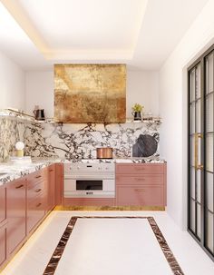 a kitchen with marble counter tops and pink cabinets, along with an area rug on the floor