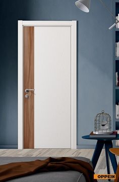 an open door in a blue room next to a table with a birdcage on it