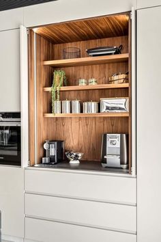 an open cabinet in a kitchen with coffee maker and toaster on the counter top