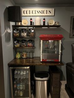 a small kitchen area with a coffee maker, refrigerator and shelves filled with condiments