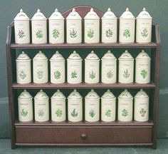 a shelf filled with lots of white canisters on top of a wooden stand