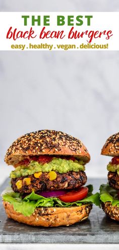 two black bean burgers with lettuce, tomato and avocado on top