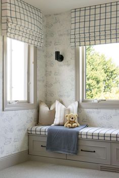 a teddy bear sitting on top of a window sill in a room with white walls