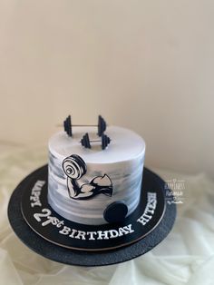 a white and black birthday cake sitting on top of a table