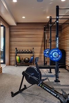 a home gym with an exercise bike and rowing machine in the middle of the room