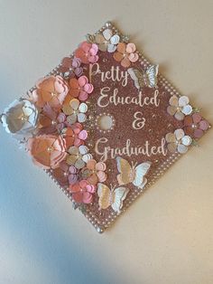 a graduation cap decorated with flowers and butterflies on the front, says pretty engaged & graduate