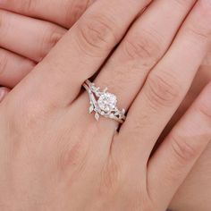 a woman's hand with a diamond ring on top of her finger and the other hand holding it