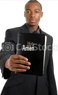 a man in a suit holding an open book with the word hok amen written on it