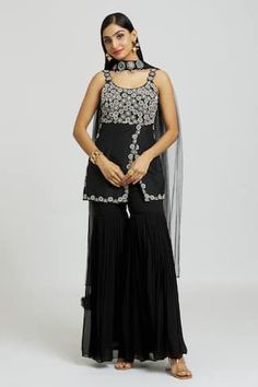 Black kurta with floral, sequins, beads and thread embroidery. Comes with gharara and a dupatta.
Components: 3
Pattern: Embroidered
Type Of Work: Floral, Sequins, Beads, Thread
Neckline: Round
Sleeve Type: Sleeveless
Fabric: Silk, Georgette, Net
Color: Black
Other Details: 
Attached lining
Length:
Kurta: 30 inches
Gharara: 43 inches
Closure: Gharara - Side zip
Note: The fabric is silk blend and not pure silk.
Occasion: Sangeet - Aza Fashions Black Kurta, Kurta Patterns, Types Of Work, Beaded Neckline, Thread Embroidery, Fabric Silk, Embroidered Silk, Set For Women, Black Silk