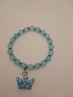 Pastel blue beaded bracelet with silver spacer beads and interchangeable pastel blue crown charm. Blue Hypoallergenic Charm Bracelet With Round Beads, Hypoallergenic Blue Charm Bracelet With Round Beads, Handmade Blue Charm Bracelet, Handmade Blue Round Charm Bracelet, Blue Beaded Charm Bracelet, Blue Nickel-free Charm Bracelet With Round Beads, Handmade Blue Charm Bracelet With Round Beads, Handmade Light Blue Stretch Bracelet With Round Beads, Blue Charm Bracelet With 8mm Beads