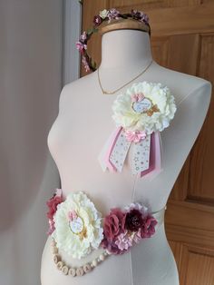 a white mannequin with pink and purple flowers on it's chest, wearing a flower crown