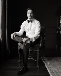 a man sitting in a chair wearing a bow tie