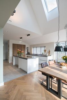 an open kitchen and dining room with skylights