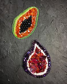 two pieces of beaded jewelry sitting on top of a black surface next to each other