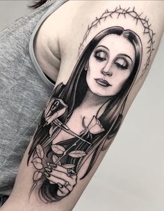 a woman's arm with a tattoo on it and a glass in her hand