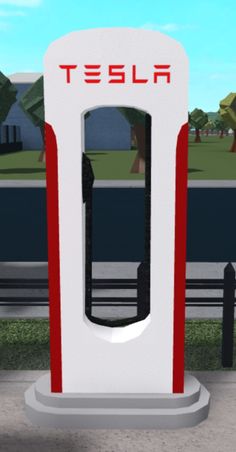 a white and red gas pump sitting on the side of a road next to a park