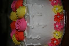 a white cake with colorful frosting flowers on it