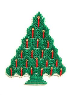 a christmas tree made out of legos on top of a white surface with red and green decorations