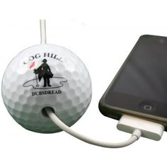 a cell phone plugged in to a golf ball with a charger on it