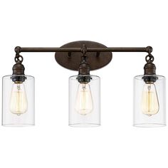 three light bathroom fixture with clear glass shades on the bottom and an old - fashioned bronze finish