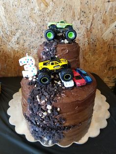 a birthday cake with monster trucks on top