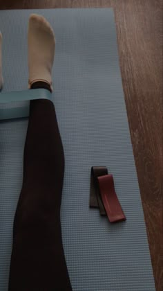 a person is doing yoga on a mat with their feet propped up and one leg resting on the mat