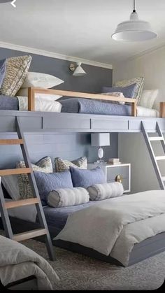 a bedroom with bunk beds and pillows on top of each bed in front of a window