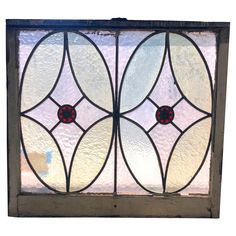 an old stained glass window with red and white flowers on it's side panel