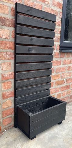 a wooden slatted bench sitting next to a brick wall with a window in the background