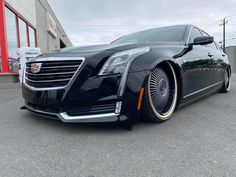 a black cadillac parked in front of a building