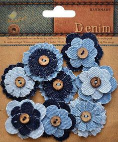 some blue flowers are sitting on a piece of cardboard with buttons in the shape of flowers