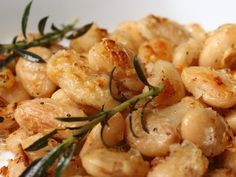 a white bowl filled with cooked shrimp and garnished with rosemary