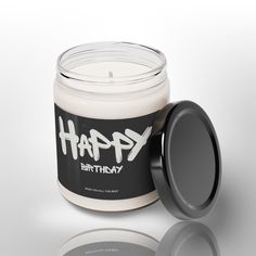 a white candle with the words x - raph on it next to a black lid