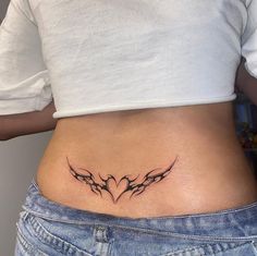 a woman with a tattoo on her stomach that has two birds in the shape of a heart