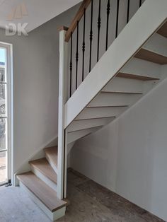 an empty room with stairs leading up to the second floor and another window in the background