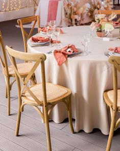 the table is set with white linens and pink napkins