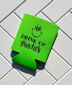 a green piece of paper with the words drink up gringies on it sitting on a white tile floor