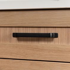 a close up of a drawer handle on a wooden cabinet