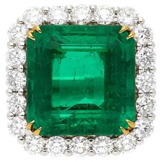 16.46 Carat Emerald-Cut vivid green Colombian Emerald framed by 48 Round-Brilliant Cut Diamonds totaling 2.60 Carats, and set in lush white and yellow 18 karat gold. This legendary center stone is of Colombian origin, and contains minor amounts of oil treatment, making this emerald gem one of superlative quality and value. Details: ✔ Stone: Emerald ✔ Center-Stone Weight: 16.46 carats ✔ Stone Cut: Emerald ✔ Stone Color: Green ✔ Stone Origin: Colombia ✔ Treatment: Minor ✔ Emerald Dimensions: 15.05