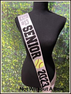 a black mannequin with a white and yellow ribbon around it's neck