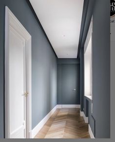 an empty room with blue walls and wood floors is seen in this image from the hallway