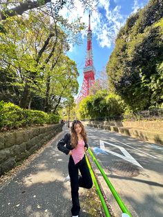 a woman is posing in front of the eiffel tower