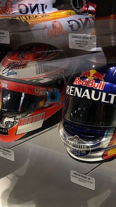 two helmets are on display in a store window, one is blue and the other is red