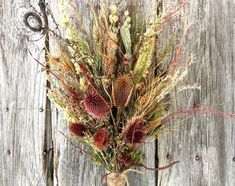 an arrangement of dried flowers in a vase