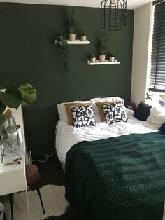 a bed sitting in a bedroom next to a window with potted plants on it