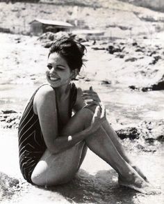 a woman is sitting in the water and smiling