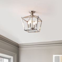 a light fixture hanging from the ceiling in a room with white walls and trimmings