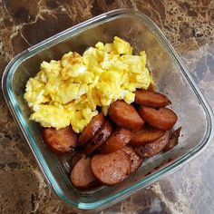 a glass bowl filled with eggs and sausage