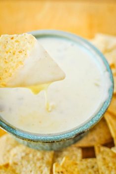 a tortilla chip dipping into a bowl of dip